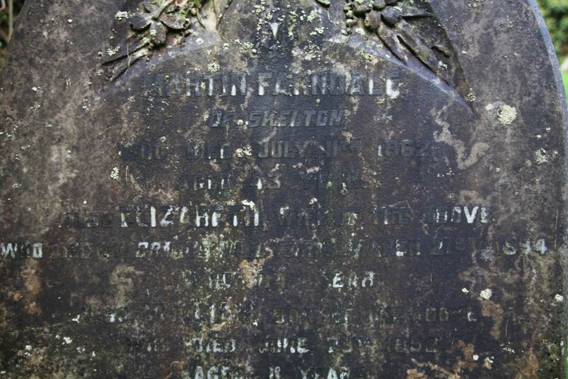Close-up of a tombstone with writing on it
Description automatically generated